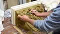 Sculptor create clay model of a Corinthian capitel with scrolls and unfurled acanthus leaves in restoration workshop