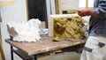 Sculptor create clay model of a Corinthian capitel with scrolls and unfurled acanthus leaves in restoration workshop