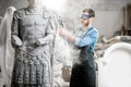 Sculptor grinding sculpture in the studio