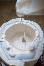 The sculptor`s hands fill the white liquid into the mold. Vertical frame Royalty Free Stock Photo