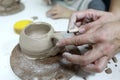 Sculptor sculpts clay mug