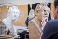 A sculptor sculpts a sculpture of a person`s face. Horizontal frame