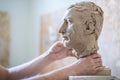 A sculptor sculpts a sculpture of a person`s face. Horizontal frame