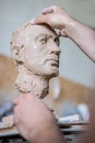 A sculptor sculpts a sculpture of a person`s face. Horizontal frame