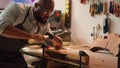 Sculptor shaping raw timber using chisel and hammer Royalty Free Stock Photo