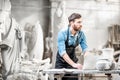 Sculptor working with laptop in the studio Royalty Free Stock Photo
