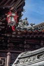 Sculptural details of ancient tiled roof of ornate pagoda with traditional lampshade. Architecture of antique building