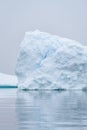 Sculptural iceberg shrouded in fog and floating in the waters of Antarctica Royalty Free Stock Photo