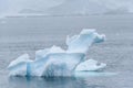 Sculptural iceberg shrouded in fog and floating in the waters of Antarctica Royalty Free Stock Photo