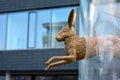 Sculpture of a bronze rabbit jumping through a glass hoop by artist Sabrina Hohmann