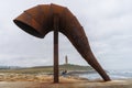 Sculpture of the Caracola and in the background the Tower of Hercules in the city of A Coruna in Galicia, Spain