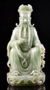 Sculpture of a Chinese God of Wealth, Hetian jade isolated on a black background Royalty Free Stock Photo