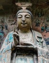 Giant statue of Buddha Sakyamuni on background of niche wall at Dazu Rock Carvings