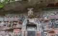 Statue of Buddha Sakyamuni on background of reliefs at Dazu Rock Carvings