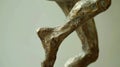 A sculpture depicting a figure midjump with one leg extended behind and the other bent at the knee. The fluidity of the