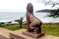 Sculpture of a fabulous red stone lion on the ocean