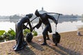 Sculpture of family life of a couple with dresses of old times: carry & pour water by Jinshan Lake