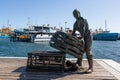 Sculpture of a fisherman in Fremantle, Australia. Tribute to the fishing industry. Fishing boats and ocean behind. West coast,