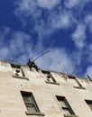 A sculpture of a fisherman installed on the top of the tall building in Oamaru, New Zealand