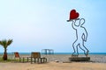 A sculpture in the form of a waiter on rollers carrying a heart on a tray. Near the cafe on the beach