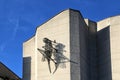 Sculpture of a grasshopper made of steel and copper wire on the wall of a building