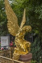 Sculpture of a grieving golden angel on a grave