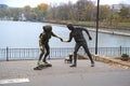 City panorama sculpture group skateboard lesson woman man dog calm lake