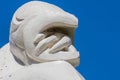 Sculpture of a human figure against a vivid blue sky background