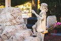 Sculpture of little angel girl at old cemetery. Closeup of stoned angel at cemetery. Graveyard old weathered stone baby statue on Royalty Free Stock Photo