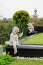 Sculpture of little angels sitting on black marble cemetery