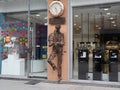 Sculpture of man checking time made of recycled metal pieces