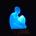 The sculpture of a man, illuminated by blue. Nice, France