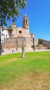 Sculpture of Mercury-Hermes in a garden in Sitges with church of Sant Bartomeu and Santa Tecla in the background, Barcelona Royalty Free Stock Photo