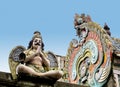 A sculpture of a mythological creature Garuda and a dragon`s head on the roof of the ancient temple in India