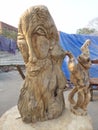 A sculpture of a old man and his monkey made off wood
