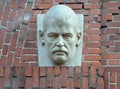 Sculpture portrait of artist Lovis Corinth on the brick facade of the building. Kaliningrad