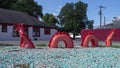 Sculpture of a red dragon snake undulating in and out of rocky ground in Dallas, Texas.