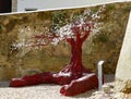 A sculpture of a red tree with white blossom