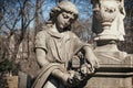 A sculpture of sad woman in grief. Virgin Mary stone statue near the funeral urn suffering, death concept