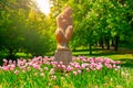 Sculpture of seated woman in Letna Park on sunny summer day with pink tulips, Prague, Czech Republic