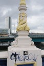 Sculpture of snakes is wrapped around the base of a light pole.