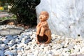 Sculpture Thai boy doll with in the pebble garden