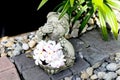 Sculpture thai girl doll with plumeria flower in the pebble garden