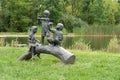 Sculpture of three children fishing on a log by Paul Anderson