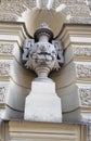 Sculpture of a vase with lion`s heads and ornaments on the wall of the building