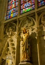 Sculpture of the Virgin Mary with the Child Jesus and Stained Glass in the St. Nazaire Basilica of the city of Carcassonne in Royalty Free Stock Photo