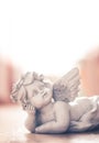 Sculpture of a white guardian angel lying on the wooden floor