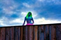 Sculpture of a woman with vibrant green hair under a cloudy sky in Jois, Austria