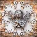 Sculpture of a wooden angel against an old classical plaster fra Royalty Free Stock Photo