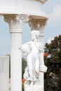 Sculpture of young woman holding basket full of grapes or fruits near corinthian columns in a public park. Replica of Royalty Free Stock Photo